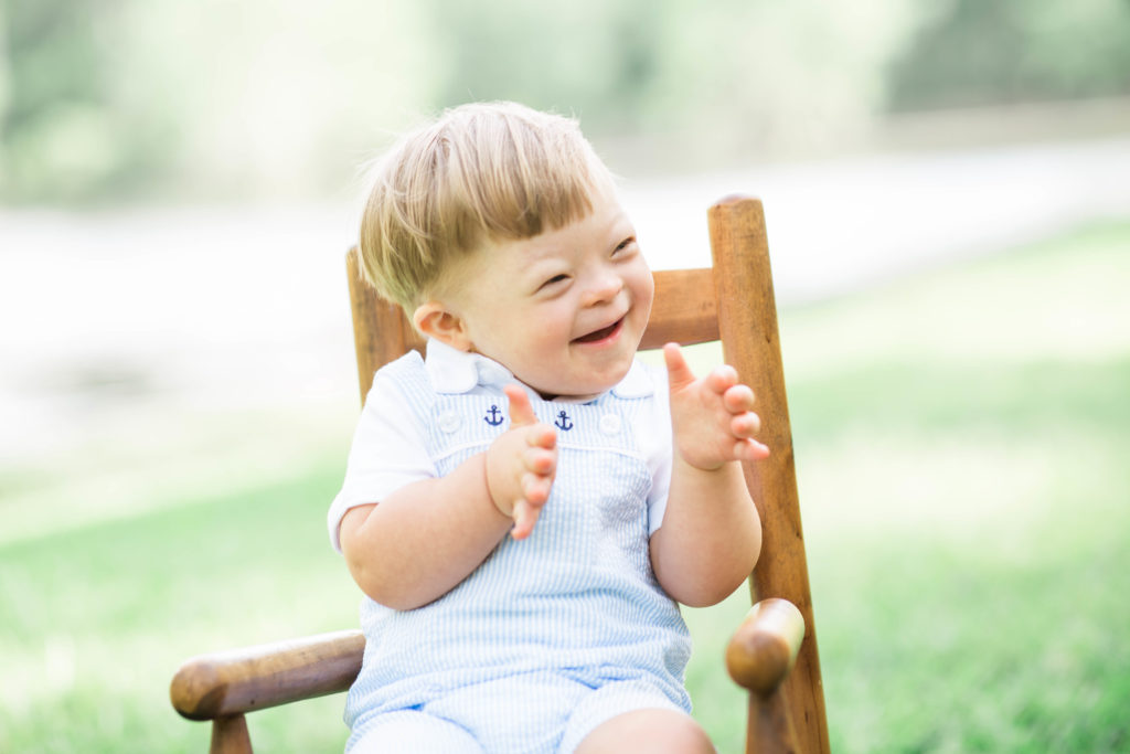 boy sitting in chair clapping hands