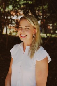 blond woman in white dress smiling outside