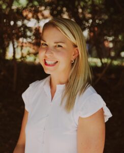 blond woman in white dress smiling outside