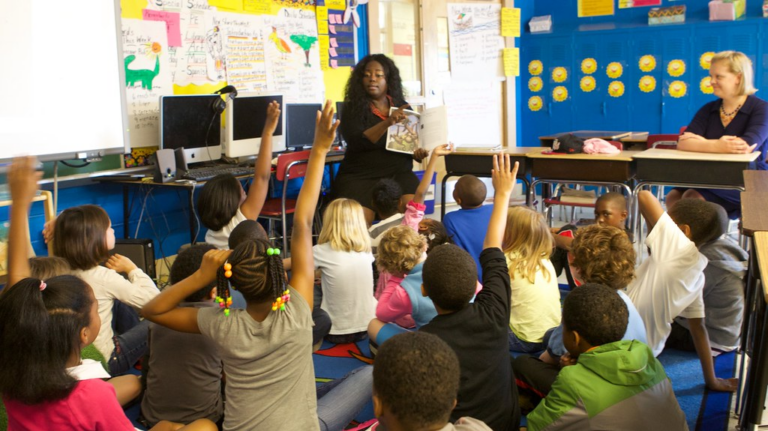 teacher reads to a group of students