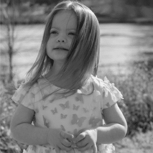 Black and white photo of toddler looking into the distance and smiling