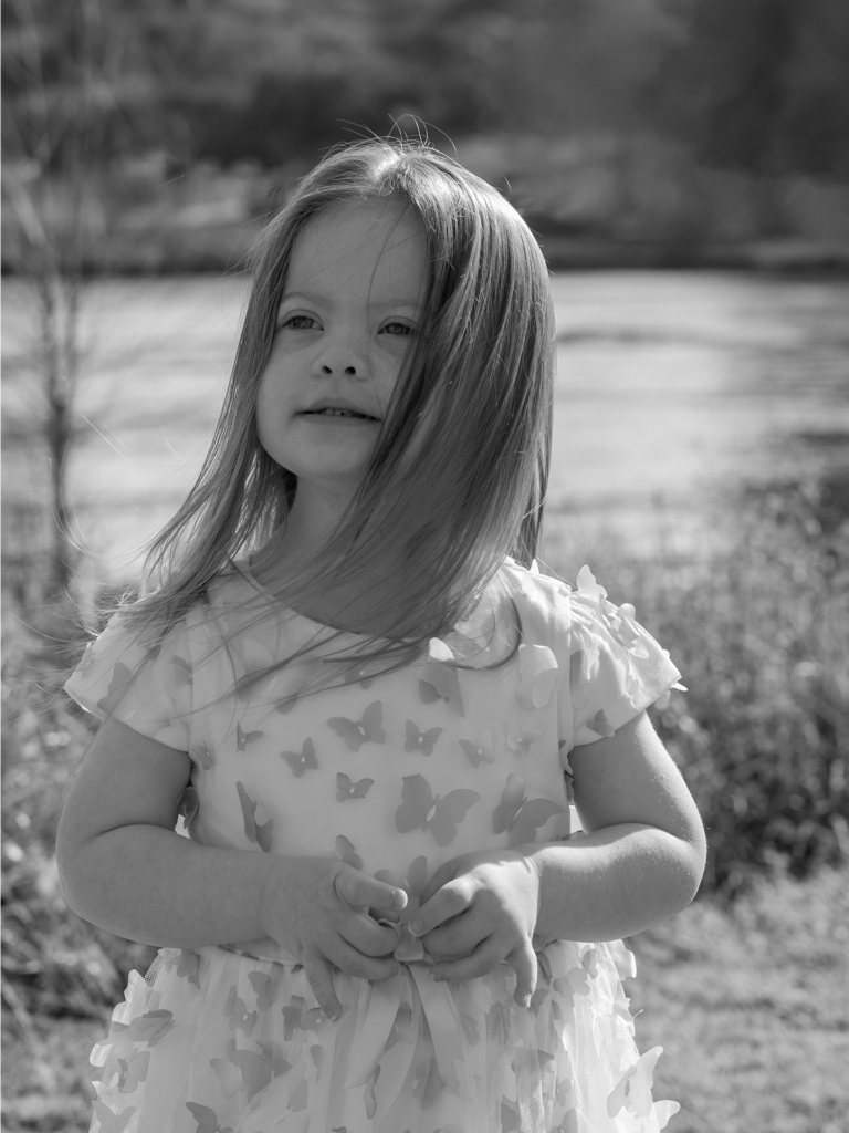 Black and white photo of toddler looking into the distance and smiling