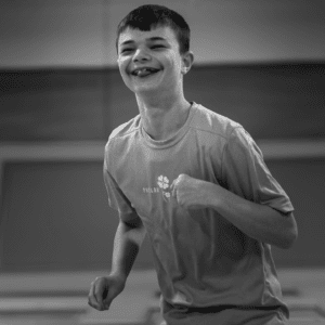 Black and white photo of a young adult male playing in a trampoline park