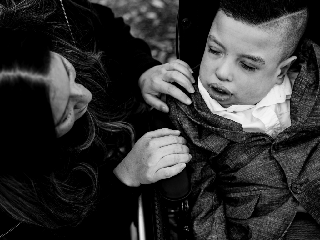 Black and white photo of male child with a parent outside